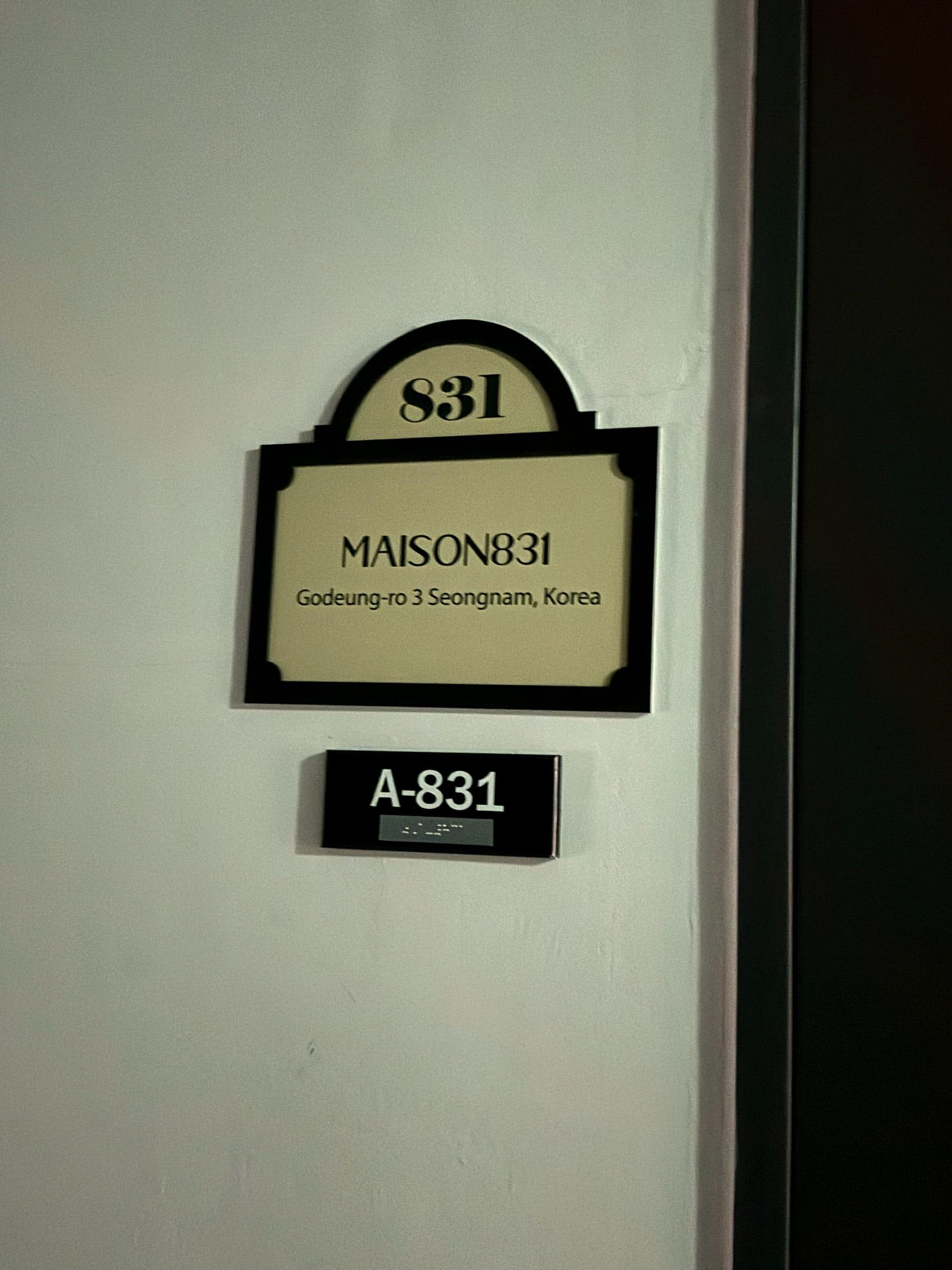 복도 벽에 걸린 MAISON831 도어 사인과 호실 번호 A-831